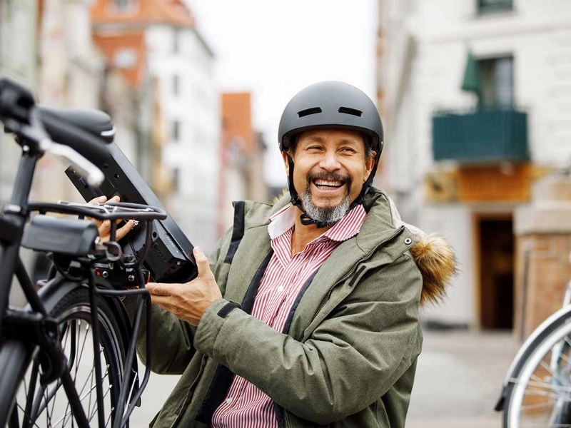 Ein lachender Mann neben seinem S-Pedelec Ein lachender Mann neben seinem S-Pedelec