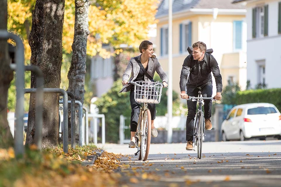 Zwei Radfahrer:innen fahren im Herbst zusammen Fahrrad Zwei Radfahrer:innen fahren im Herbst zusammen Fahrrad