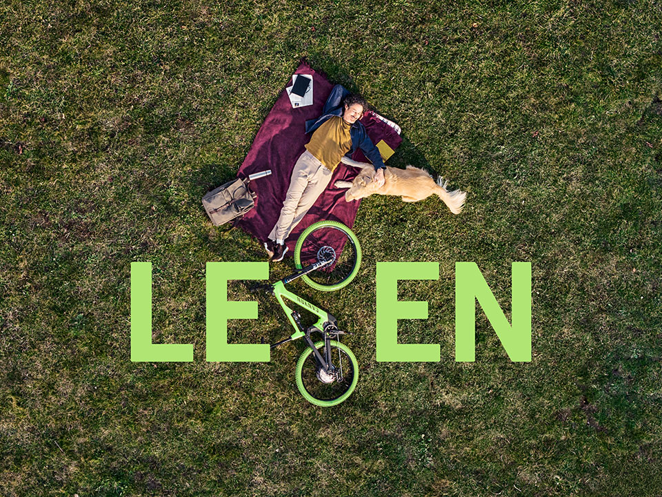 Glücklicher Fahrradfahrer liegt auf einer Wiese mit Hund Glücklicher Fahrradfahrer liegt auf einer Wiese mit Hund